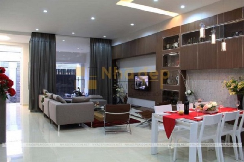 Cách trang trí phòng khách với gam màu trầm kết hợp với bộ sofa chữ L tạo cho không gian nhìn rộng rãi hơn so với diện tích